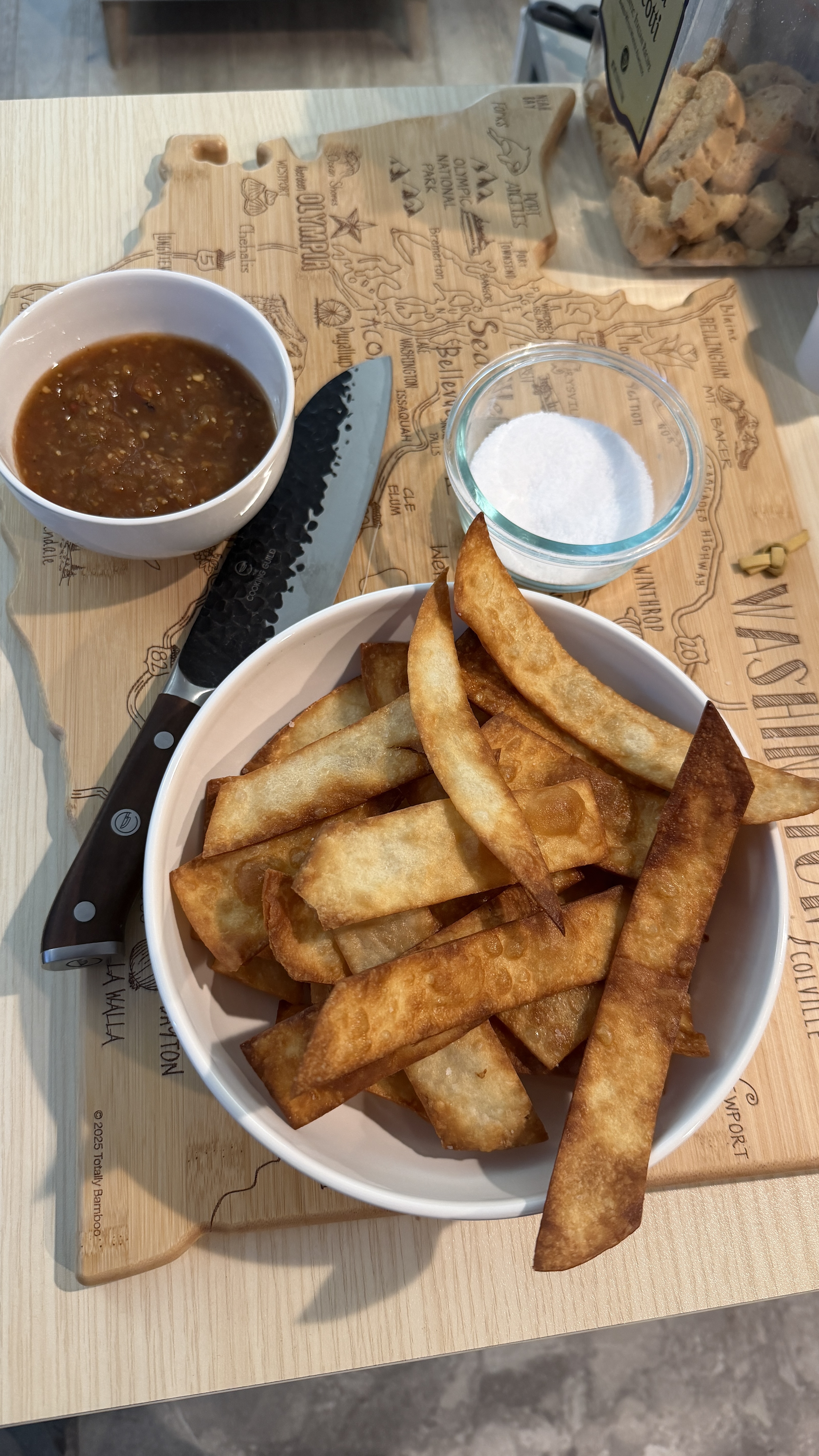 Fried tortilla chips in a bowl with salsa and salt
